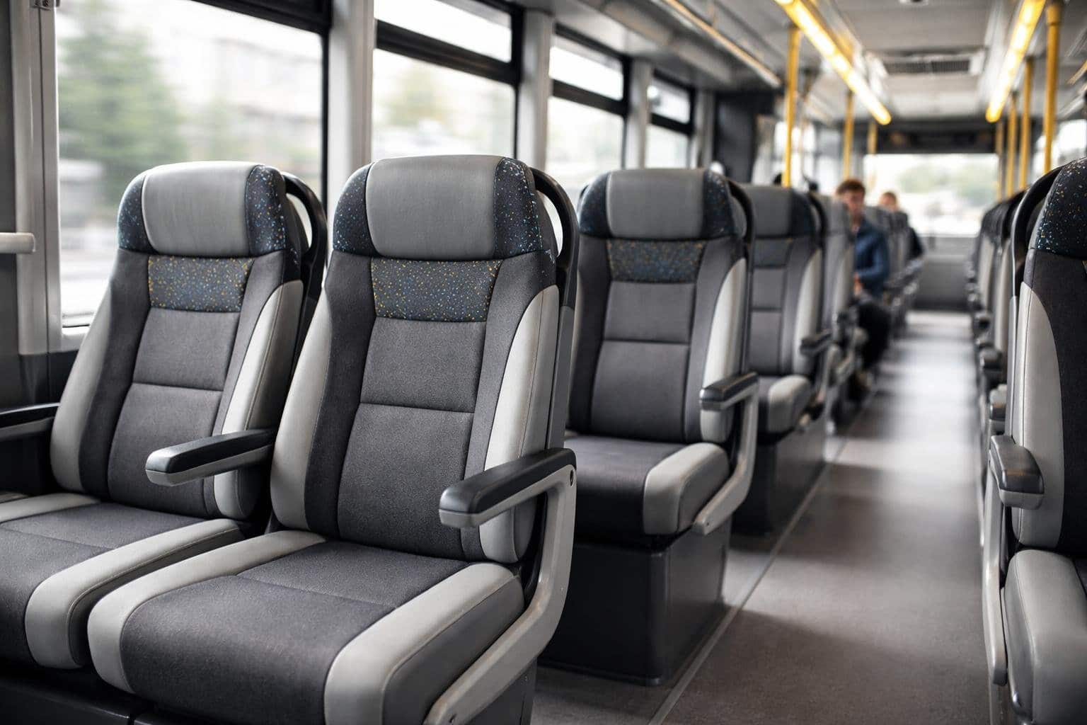 Interior de um ônibus moderno mostrando fileiras de assentos confortáveis e passageiros sentados.