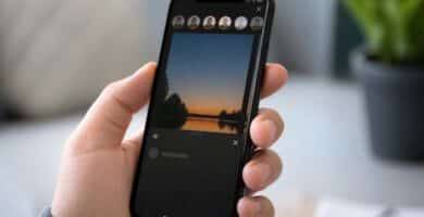 Pessoa segurando um smartphone mostrando uma história de rede social com um perfil que visualizou, mas sem o nome ou ícone visível.